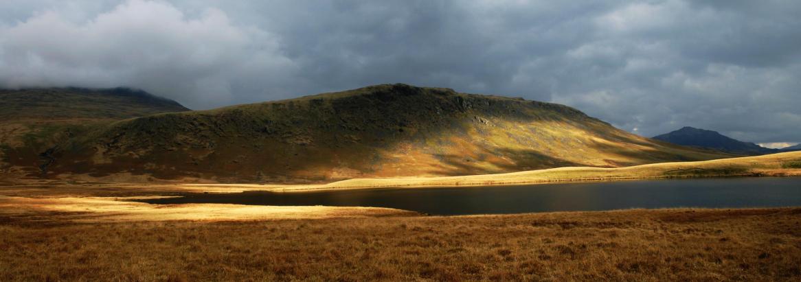 20050328-165024.jpg - A patch of afternoon sun highlights Great How across Burnmoor Tarn