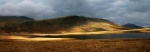 A patch of afternoon sun highlights Great How across Burnmoor Tarn